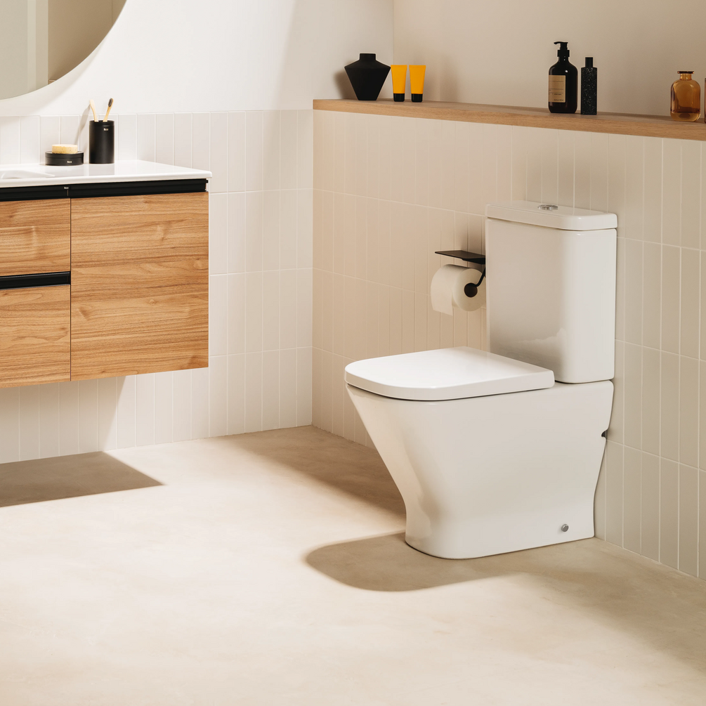 Lifestyle image of the Roca The Gap Square Close Coupled Back to Wall Compact Toilet against a tiled toilet bathroom wall